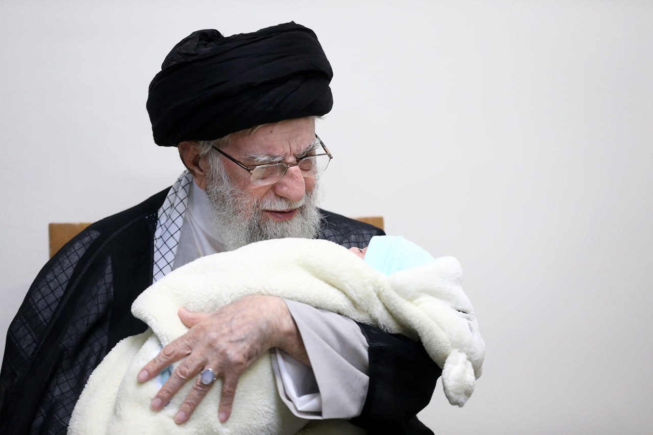 عکس / اذان گفتن رهبر انقلاب در گوش نوزاد شهید حمزه جهاندیده